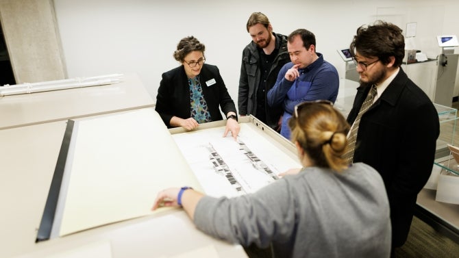 Faculty gather around special collection